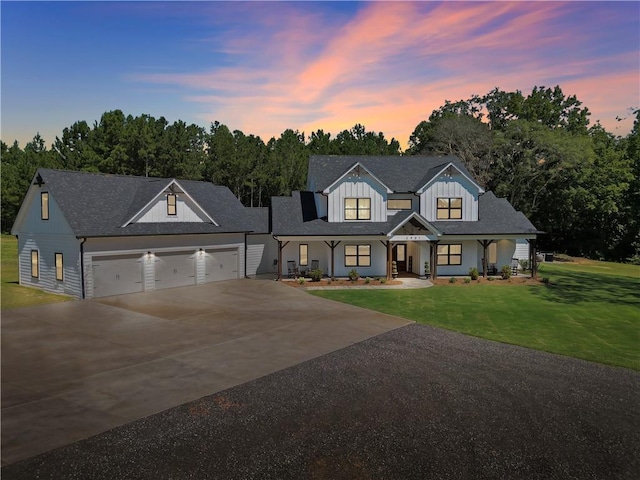 modern farmhouse style home featuring a yard, a garage, and a porch