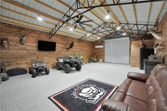 garage featuring ceiling fan and wood walls