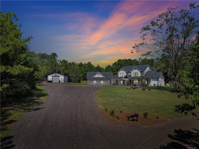 view of front facade featuring a garage, an outdoor structure, and a lawn