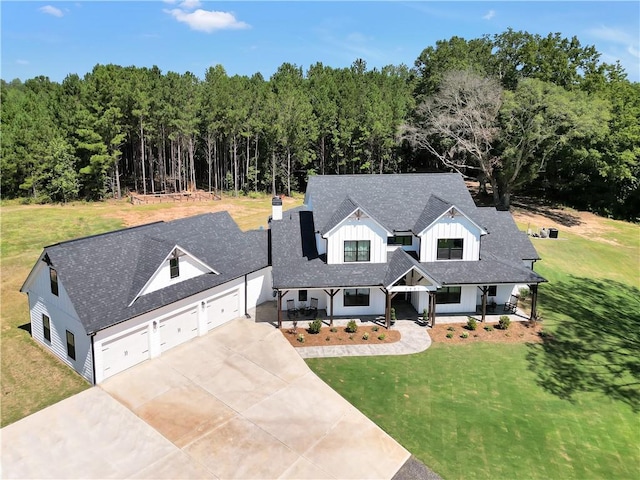 modern farmhouse style home with a garage, covered porch, and a front lawn