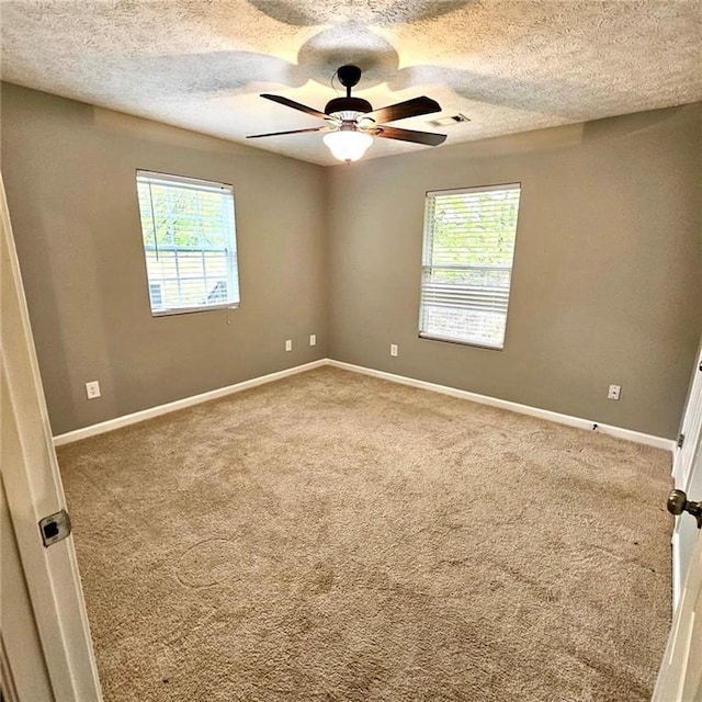 empty room with a textured ceiling, visible vents, carpet flooring, and ceiling fan