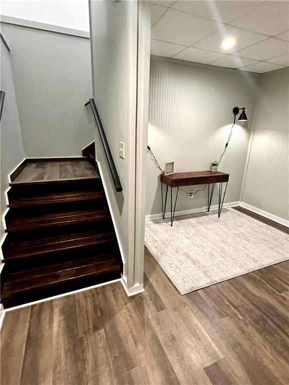 stairway with wood finished floors and baseboards