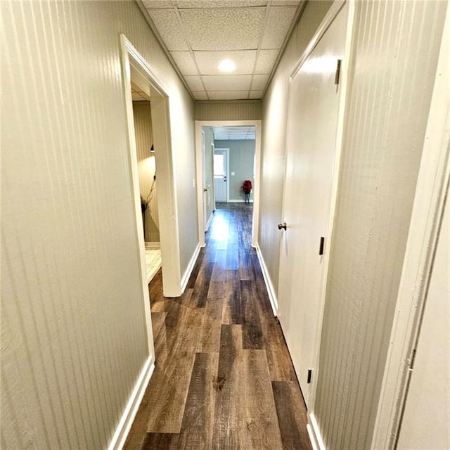 corridor with wood finished floors and baseboards