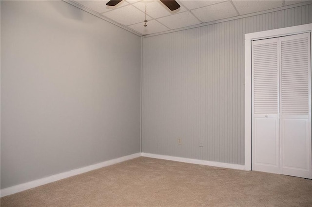 unfurnished bedroom featuring carpet floors, a closet, a ceiling fan, and baseboards
