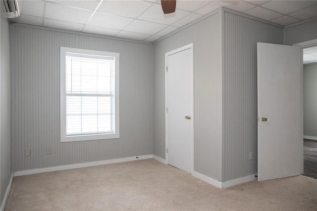 empty room featuring a wealth of natural light, carpet flooring, and a paneled ceiling