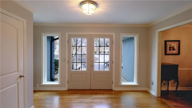 entryway with ornamental molding, light hardwood / wood-style flooring, and french doors