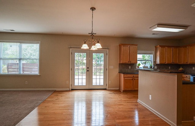 4032 Duran Ln, Auburn, GA 30011 - kitchen with dark countertops, decorative backsplash, light wood-style floors, and decorative light fixtures