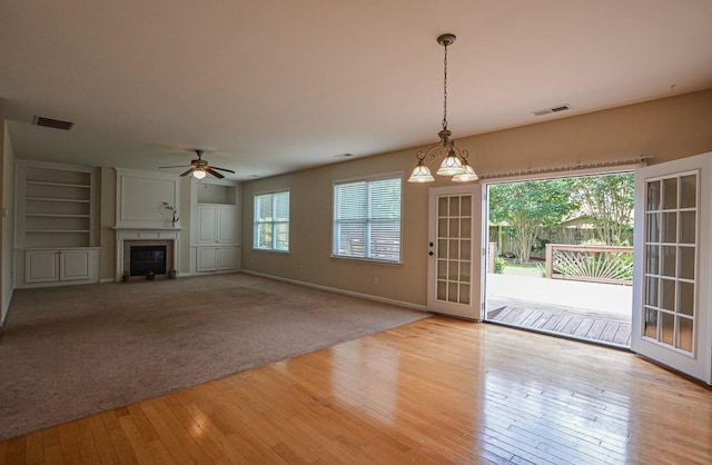 4032 Duran Ln, Auburn, GA 30011 - unfurnished living room featuring hardwood / wood-style floors, ceiling fan, a glass covered fireplace, and built in shelves
