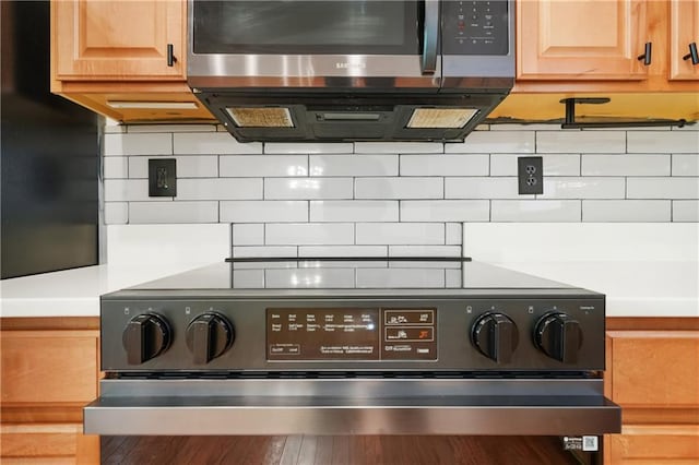 6887 Slate Stone Way SE Unit 3, Mableton, GA 30126 - kitchen view of stainless steel microwave, electric stove, decorative backsplash, and light countertops