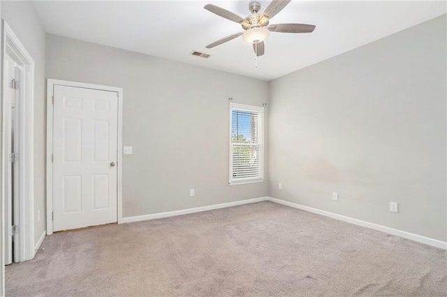 carpeted spare room featuring ceiling fan