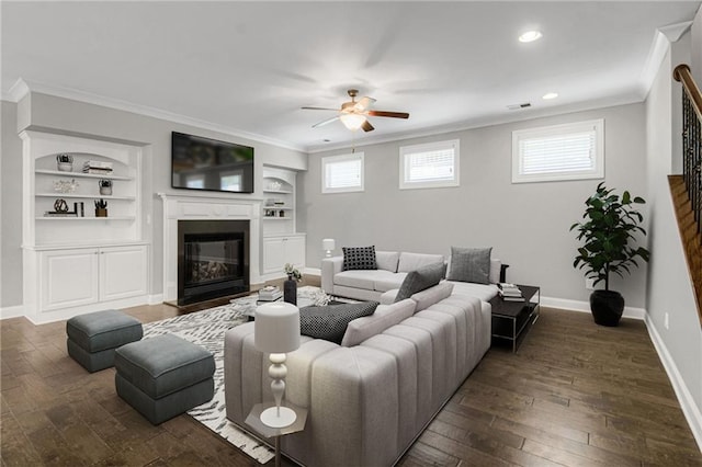 4204 Hardy Ave, Smyrna, GA 30082 - living room with ornamental molding, a ceiling fan, dark wood-type flooring, baseboards, and a glass covered fireplace