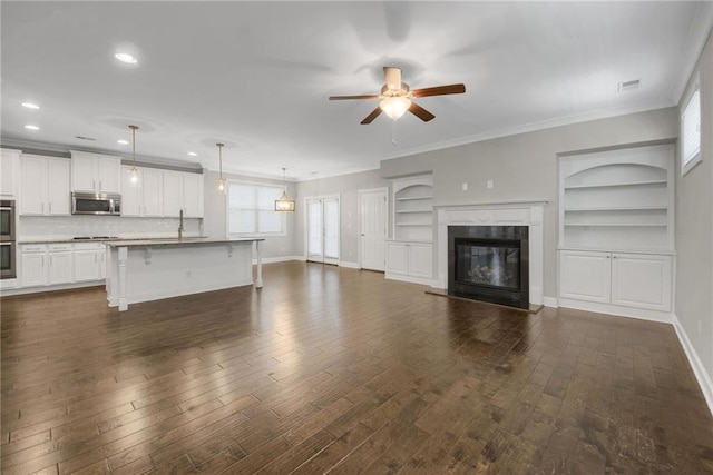 4204 Hardy Ave, Smyrna, GA 30082 - unfurnished living room with ceiling fan, baseboards, dark wood-type flooring, crown molding, and recessed lighting