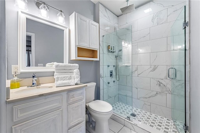 bathroom with vanity, toilet, and a shower with shower door