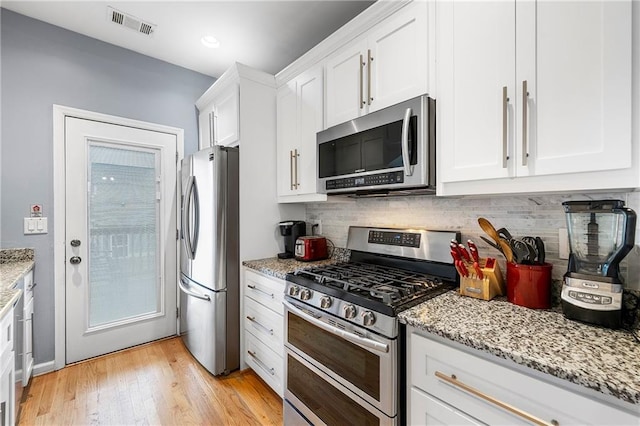 kitchen featuring light hardwood / wood-style floors, light stone countertops, white cabinetry, and stainless steel appliances