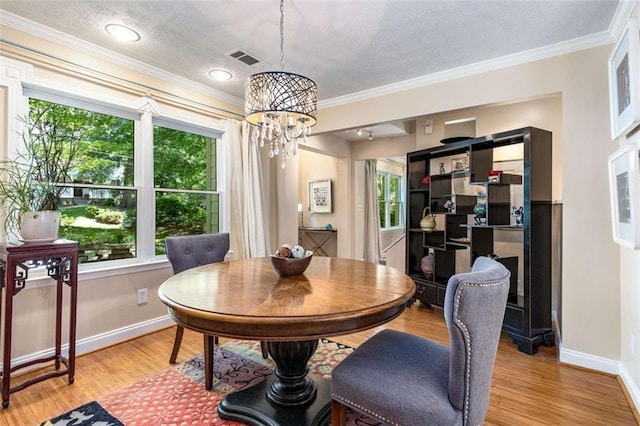 1071 Standard Dr NE, Brookhaven, GA 30319 - dining room featuring a chandelier, baseboards, a textured ceiling, light wood finished floors, and ornamental molding