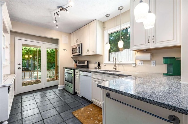 1071 Standard Dr NE, Brookhaven, GA 30319 - kitchen featuring stainless steel appliances, a sink, hanging light fixtures, dark stone countertops, and rail lighting