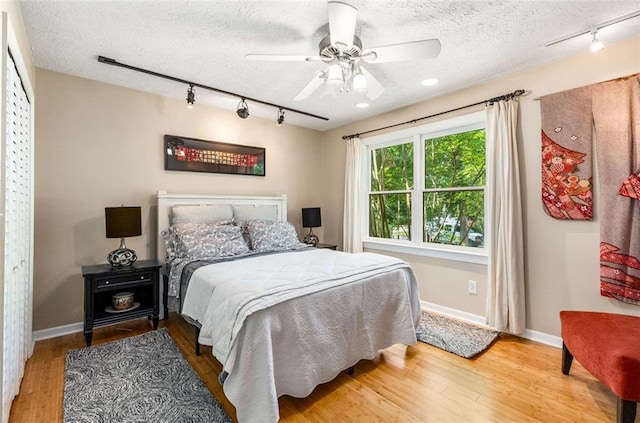 1071 Standard Dr NE, Brookhaven, GA 30319 - bedroom featuring rail lighting, a textured ceiling, wood finished floors, baseboards, and ceiling fan
