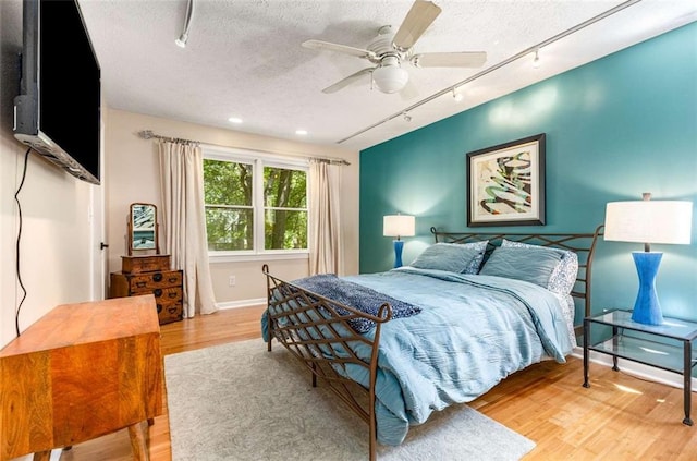 1071 Standard Dr NE, Brookhaven, GA 30319 - bedroom featuring rail lighting, wood finished floors, a textured ceiling, a ceiling fan, and baseboards
