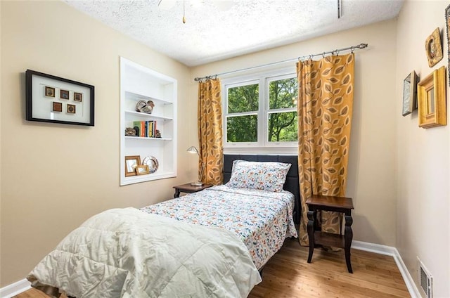 1071 Standard Dr NE, Brookhaven, GA 30319 - bedroom featuring a textured ceiling, baseboards, wood finished floors, and ceiling fan