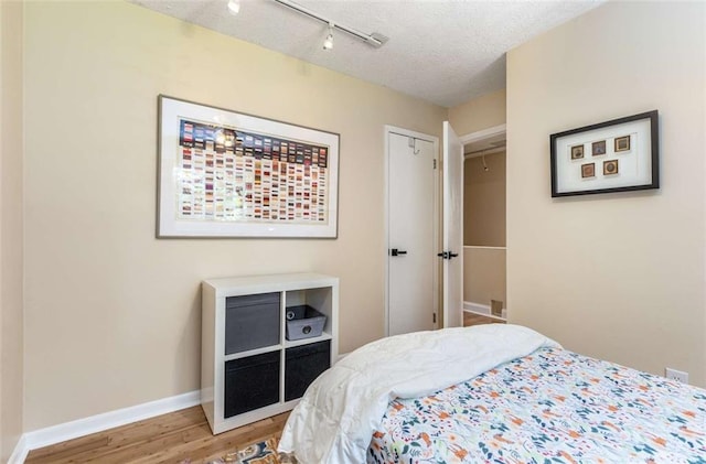 1071 Standard Dr NE, Brookhaven, GA 30319 - bedroom featuring light wood finished floors, rail lighting, baseboards, and a textured ceiling