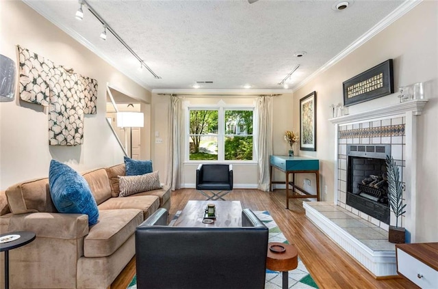 1071 Standard Dr NE, Brookhaven, GA 30319 - living room with rail lighting, a fireplace, ornamental molding, wood finished floors, and a textured ceiling