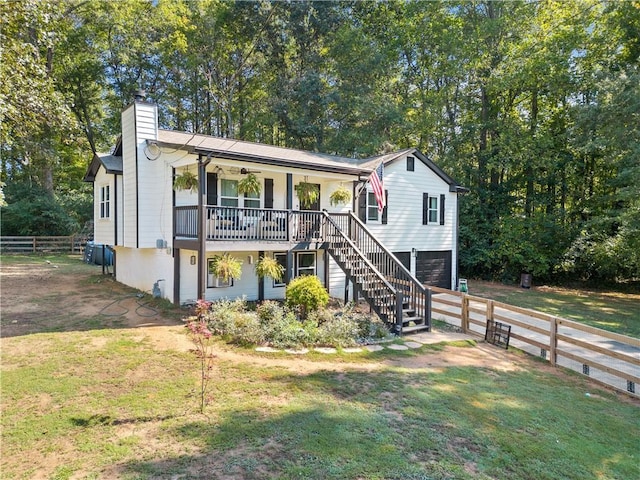 view of front of home with a garage, a front yard, and covered porch