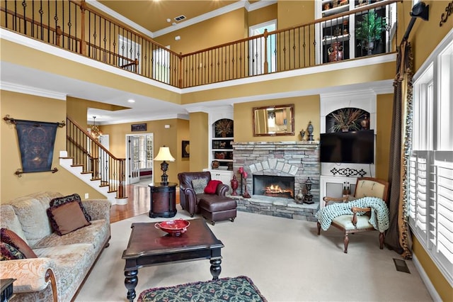 living area featuring visible vents, stairs, ornamental molding, and a fireplace