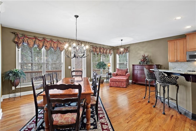 dining room with an inviting chandelier, baseboards, light wood-style floors, and recessed lighting