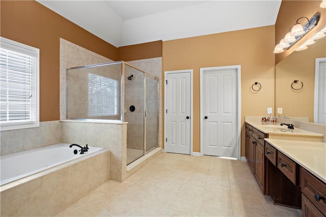 full bath with a sink, double vanity, a stall shower, and a garden tub