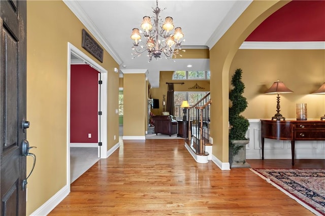 foyer featuring stairs, ornamental molding, light wood-type flooring, and baseboards