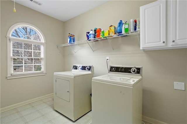 clothes washing area featuring visible vents, baseboards, independent washer and dryer, cabinet space, and light floors