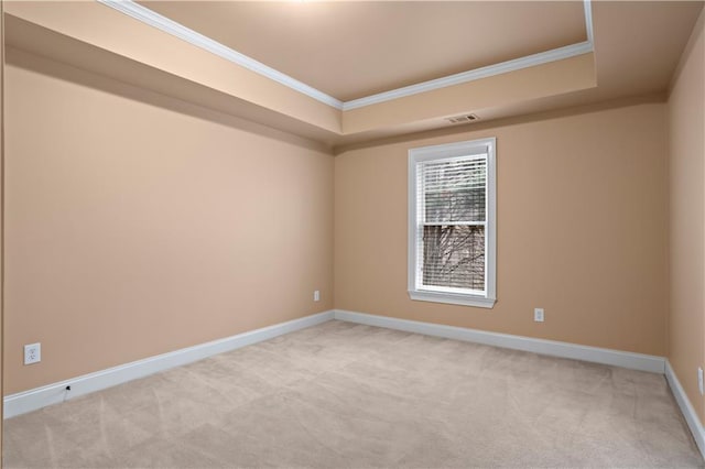 unfurnished room featuring visible vents, a raised ceiling, light colored carpet, and crown molding