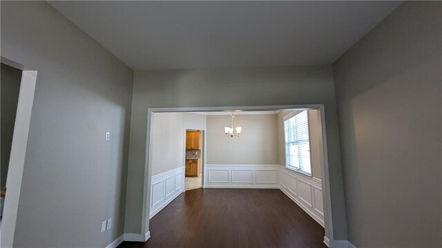 spare room with a chandelier and hardwood / wood-style flooring