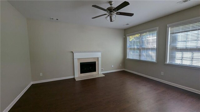 unfurnished living room featuring ceiling fan, a high end fireplace, and wood-type flooring