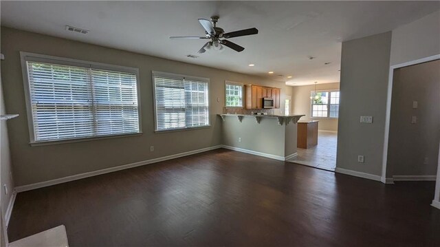 unfurnished living room featuring ceiling fan and dark hardwood / wood-style floors