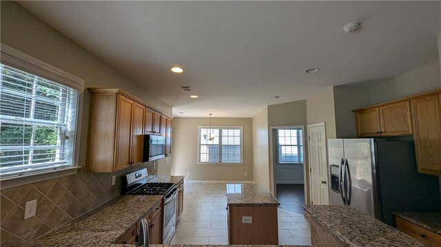 kitchen with a wealth of natural light, stainless steel appliances, a center island, and tile patterned floors