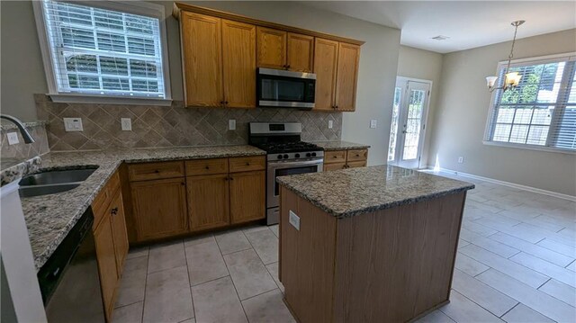 kitchen with backsplash, a notable chandelier, light stone countertops, light tile patterned floors, and stainless steel appliances