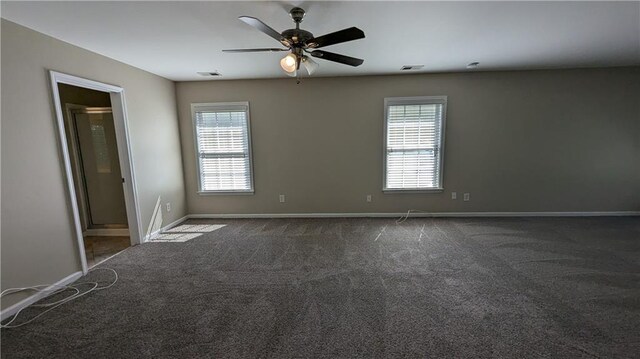 carpeted empty room with ceiling fan and plenty of natural light