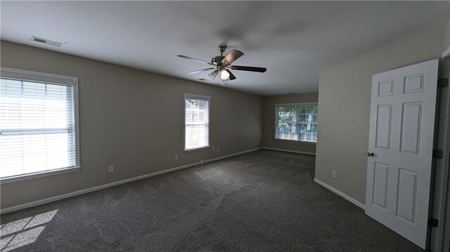 unfurnished room with ceiling fan and dark carpet