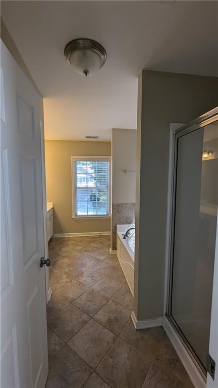 bathroom with plus walk in shower, vanity, and tile patterned floors