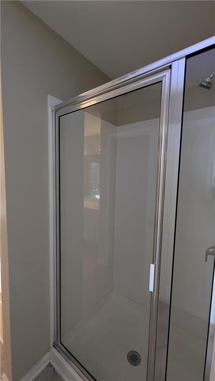 bathroom with a shower with door