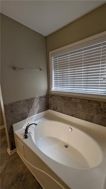 bathroom featuring a washtub and tile patterned floors