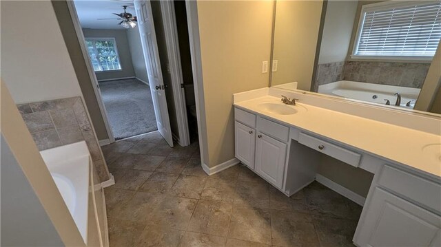 bathroom featuring a bath, plenty of natural light, and vanity