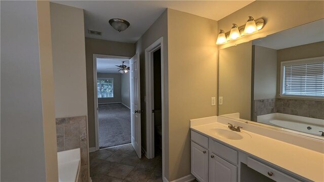 bathroom with tile patterned floors, ceiling fan, a bath, and vanity