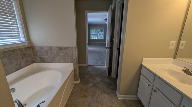 bathroom with tile patterned floors, a bathing tub, and vanity