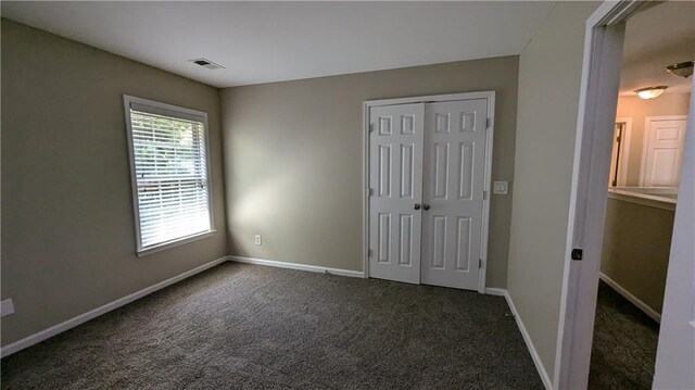 unfurnished bedroom with a closet and carpet floors