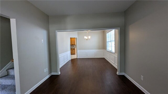 hall featuring dark hardwood / wood-style floors and a chandelier