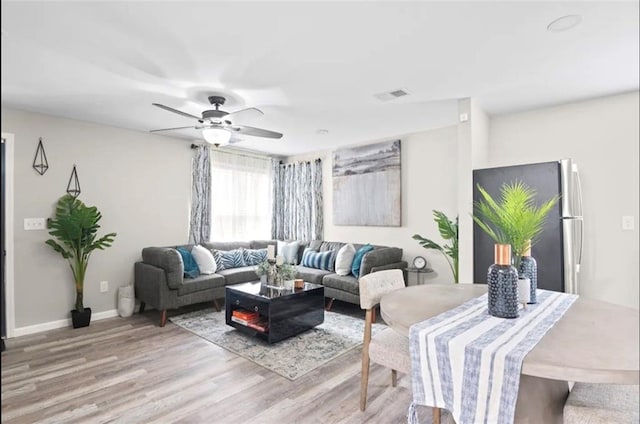 living room featuring ceiling fan and light wood-type flooring