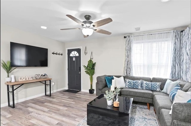 living room with light hardwood / wood-style flooring and ceiling fan