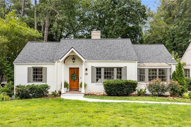 711 Greenview Ave NE, Atlanta, GA 30305 - view of front facade with a chimney, roof with shingles, a front yard, and brick siding